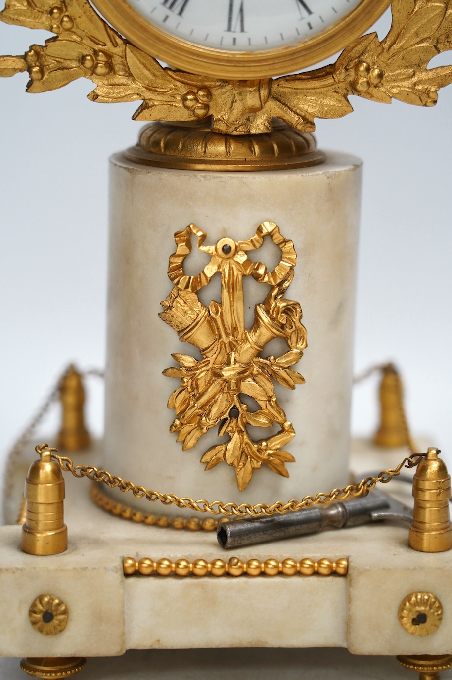 A late 19th century French alabaster and gilt metal timepiece with enamel dial, with key, 31cm high. Condition - fair